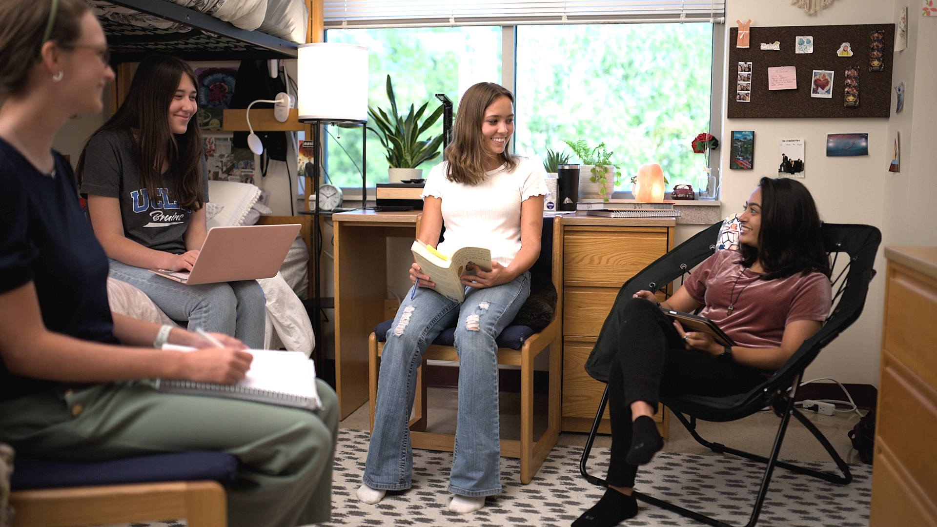 Four female students study together in a residence hall room.